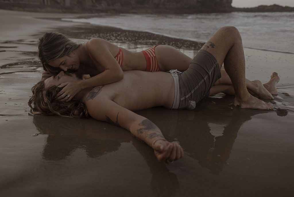couple laying in ocean kissing