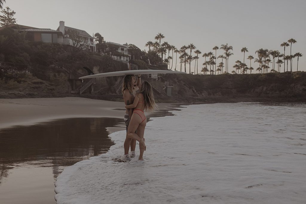 couple hugging in the water at laguna beach