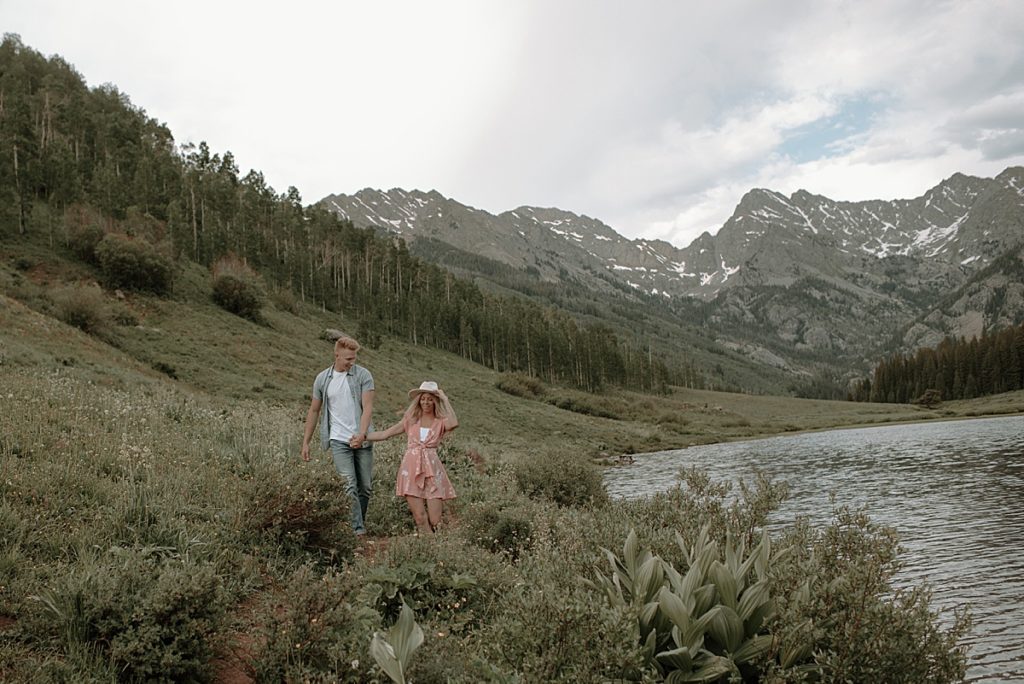 couple holding hands in the mountains of colorado