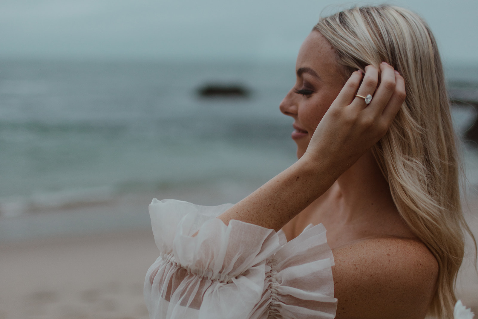 photo of bride holding her hair up at beach elopement