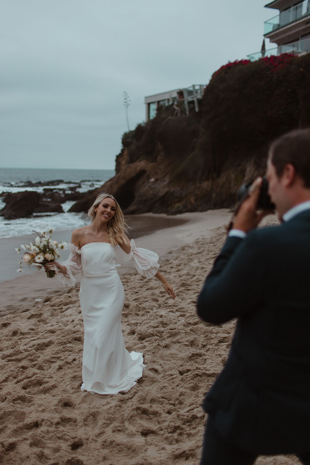 groom taking photos of bride at beach elopement