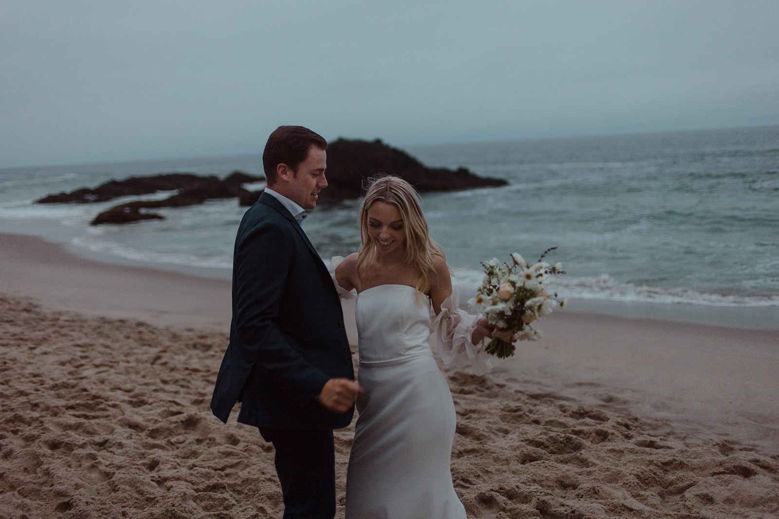 California Coast Blue Hour Elopement at Laguna Beach with bride and groom holding each other and beautiful beach backdrops