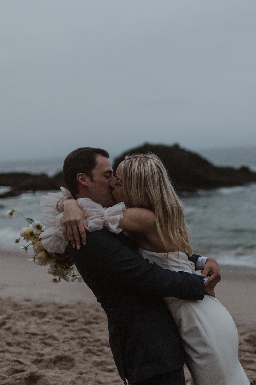 bride and groom kissing during beach elopement in laguna beach