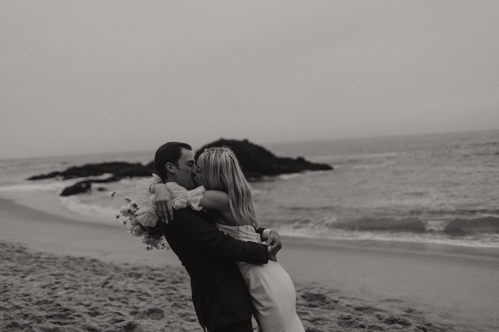 bride and groom kissing during beach elopement in laguna beach