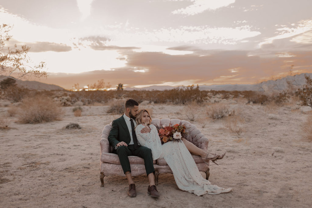 bride and groom sitting on vintage couch at joshua tree