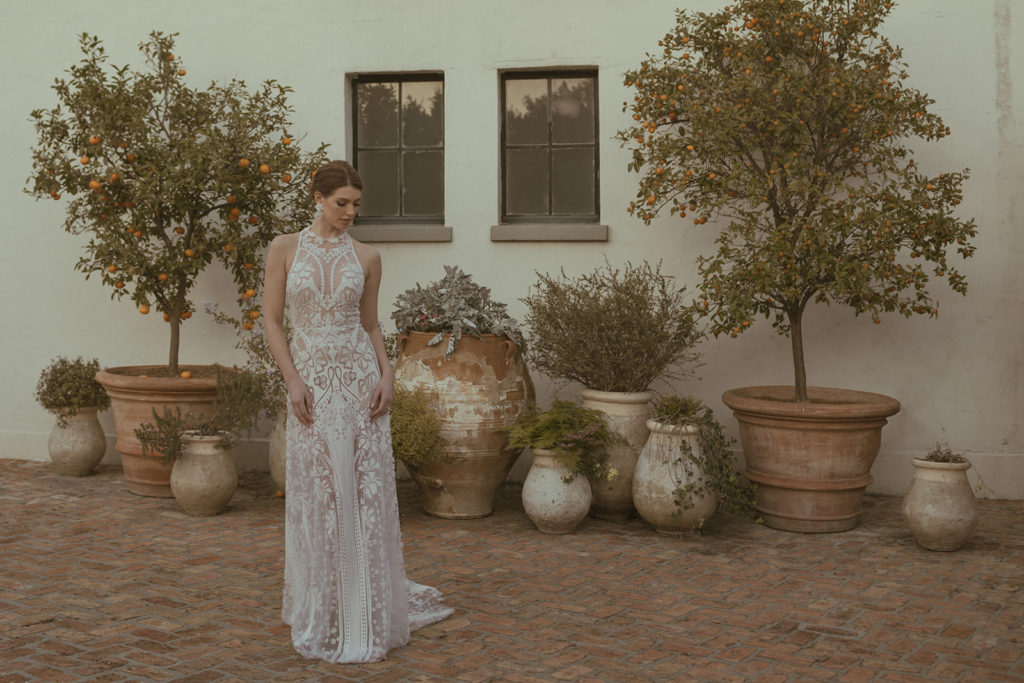 bride standing outside with lace wedding dress on