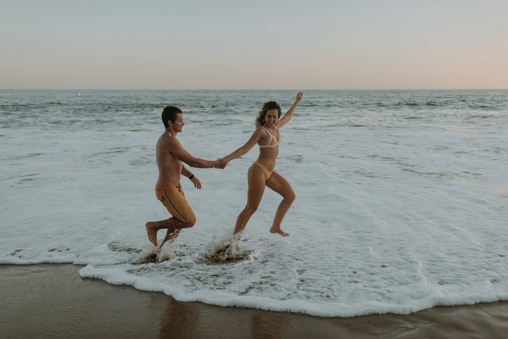 couple running on beach during photos