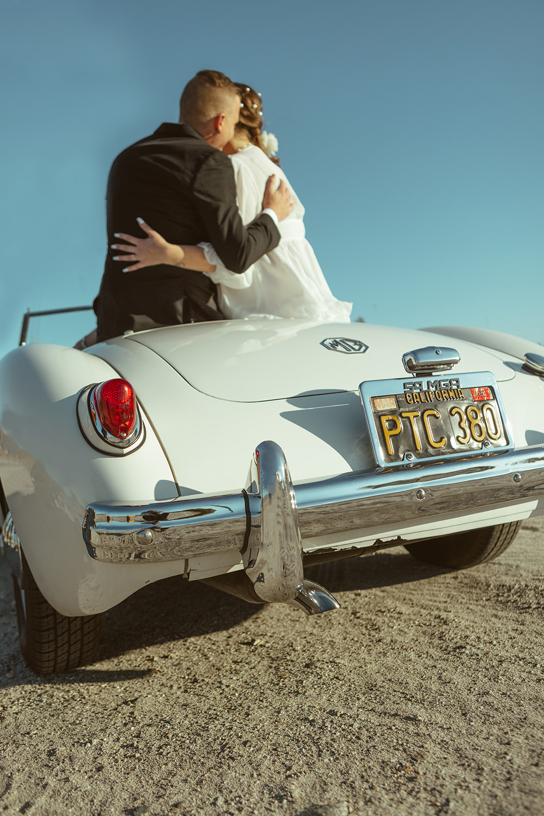 retro themed elopement at windmills of palm springs with couple sitting in retro car