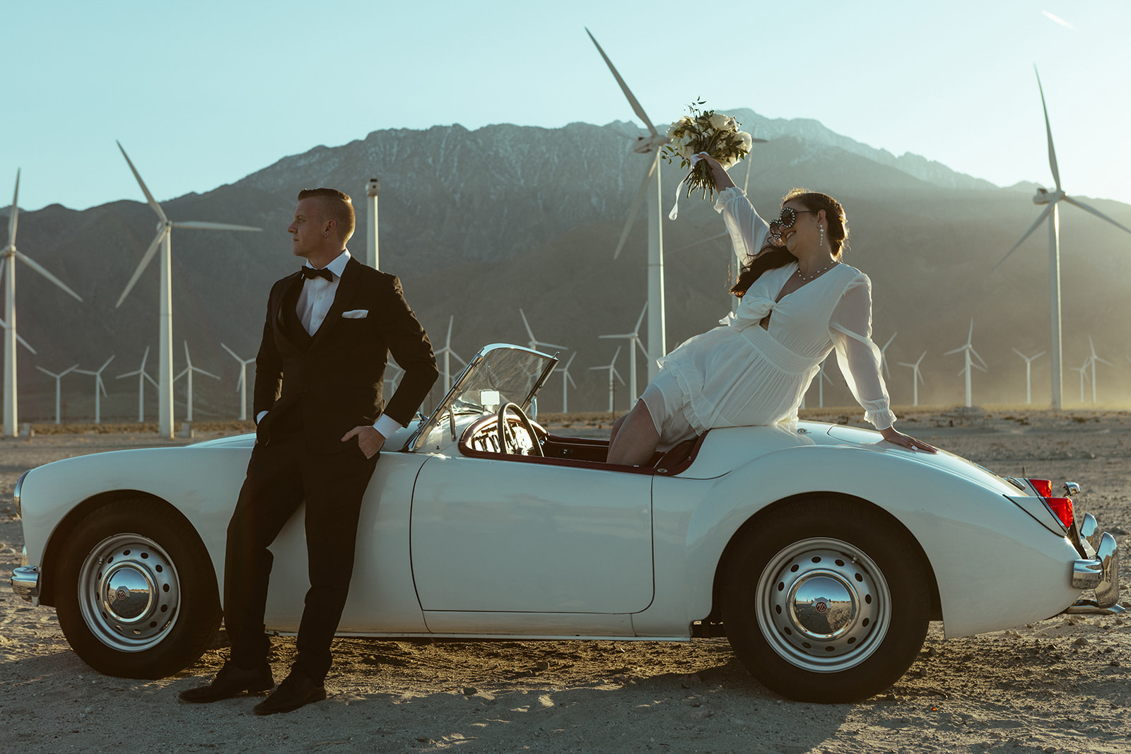 retro themed elopement at windmills of palm springs with couple sitting in retro car