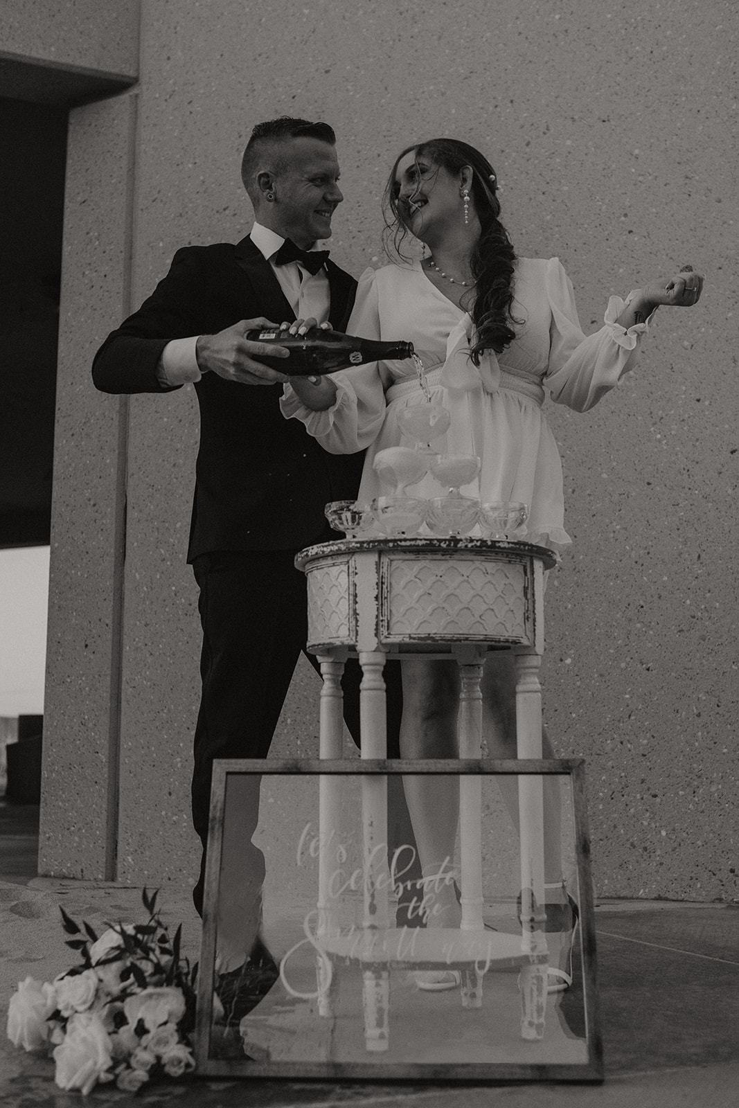 couple pouring champagne during retro themed palm springs elopement