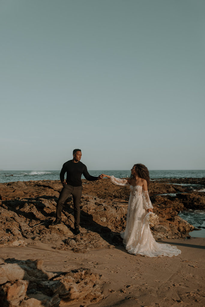 Southern California Beach Elopement at Laguna Beach with beautiful beach backdrop and couple holding hands